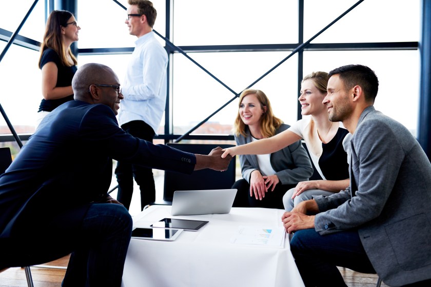 Black executive shaking hands with female colleague