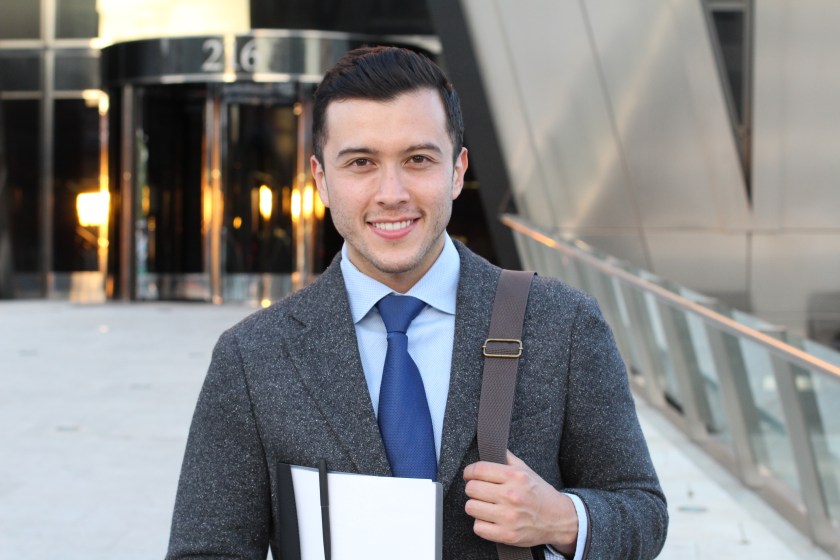 Handsome businessman smiling outside the office building